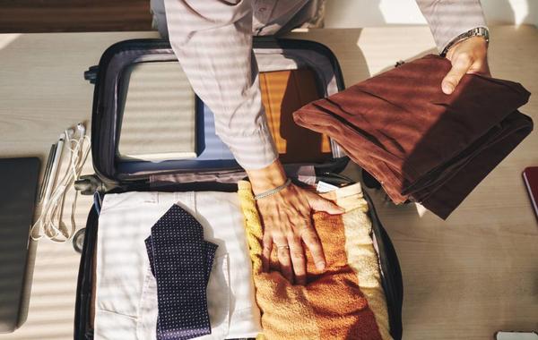 طي ولف الملابس بطريقة مناسبة داخل حقيبة السفر