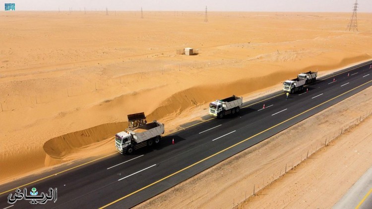 "النقل" تواصل جهودها في معالجة زحف الرمال على حرم الطريق
