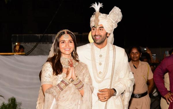 Bollywood actors Ranbir Kapoor (R) and Alia Bhatt gesture as they pose for pictures during their wedding ceremony in Mumbai on April 14, 2022. SUJIT JAISWAL / AFP